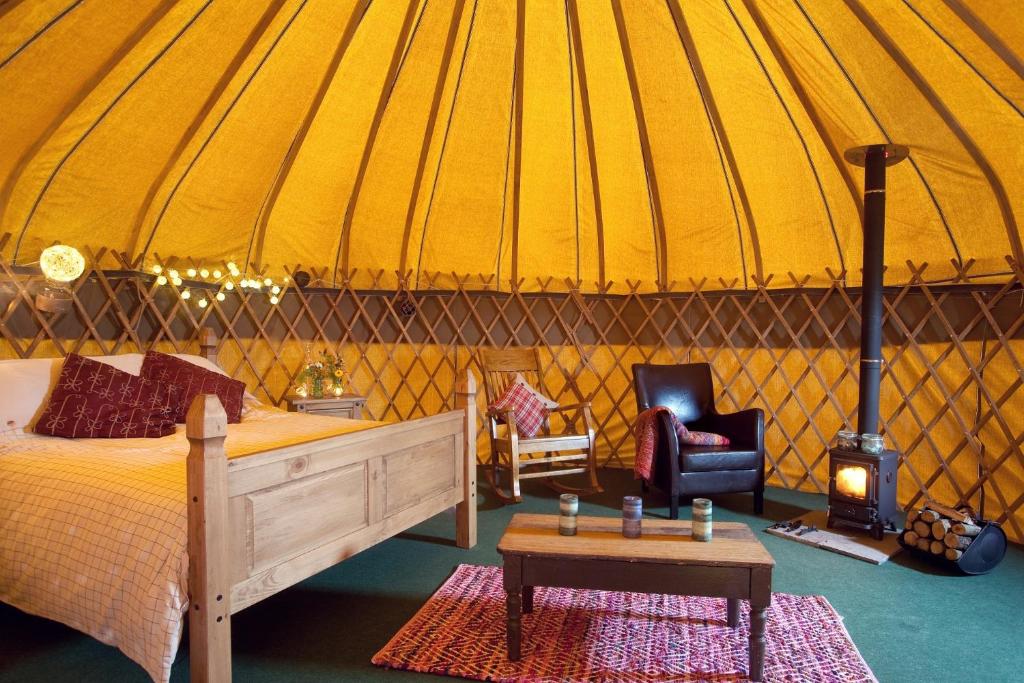 a bedroom with a bed and a stove in a yurt at Portsalon Luxury Camping in Portsalon