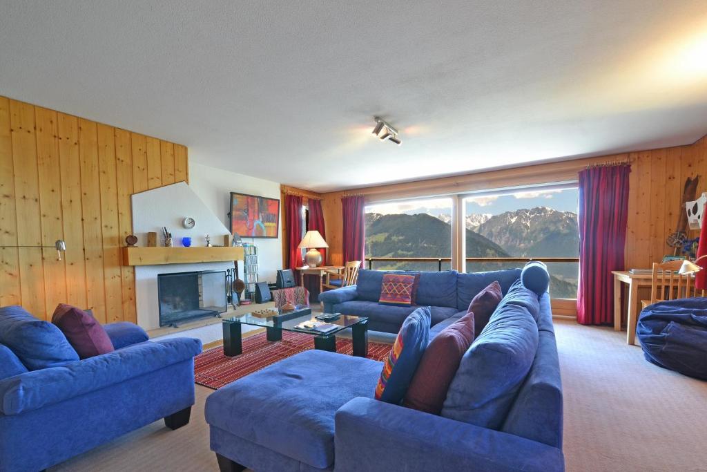a living room with two blue couches and a fireplace at Beauvoir 318 in Verbier