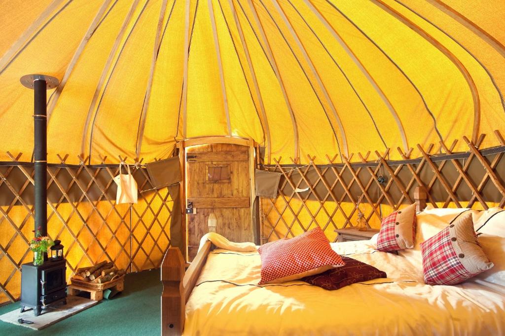 a large yellow tent with a bed in it at Portsalon Luxury Camping in Portsalon