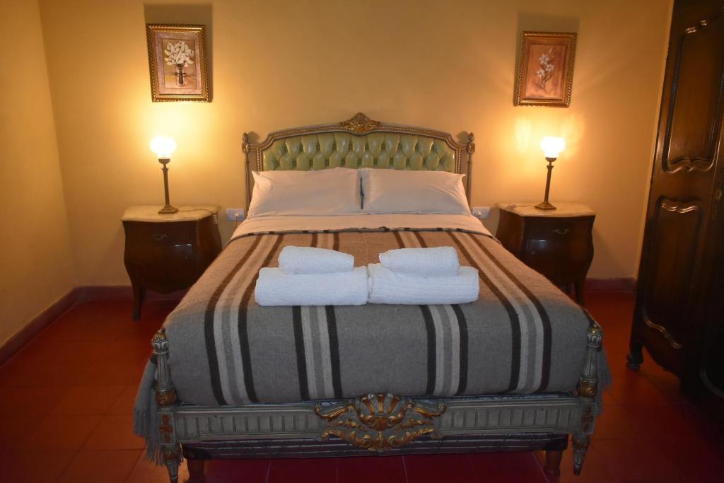 1 dormitorio con 1 cama con 2 toallas en La Sala Hotel Boutique en Tinogasta