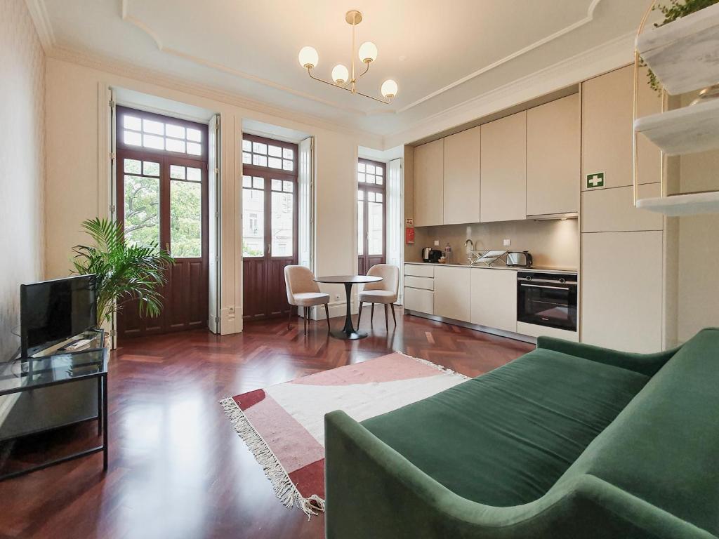 un soggiorno con un divano verde e una cucina di Trindade Premium Apartments a Porto