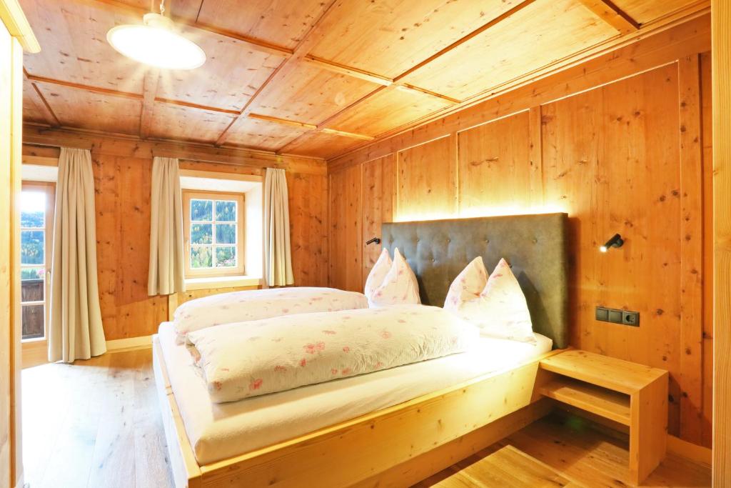 1 dormitorio con 1 cama en una habitación de madera en Hanslerhof, en Braies
