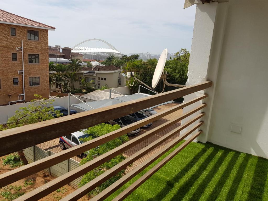 einen Balkon mit grünem Gras und Blick auf ein Gebäude in der Unterkunft ARCHITECTs VIEW - SUIT 2 in Durban