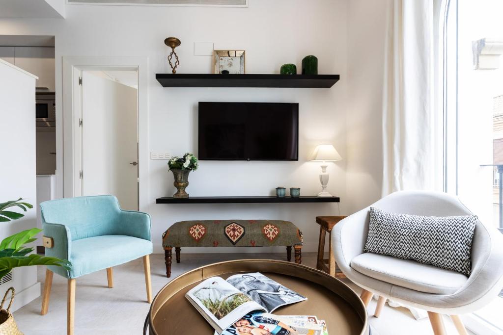 salon z 2 krzesłami i telewizorem w obiekcie Genteel Home Mateos Gago w Sewilli