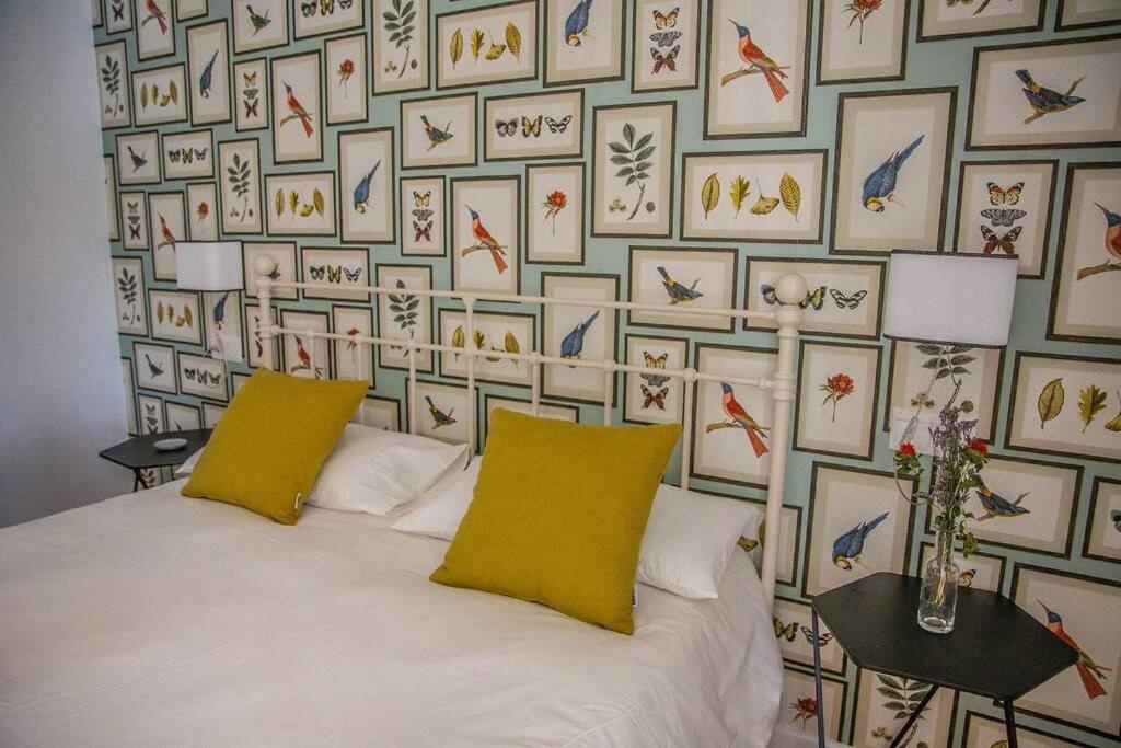 - un lit avec 2 oreillers jaunes et un mur de photos dans l'établissement Next to the Mushrooms, bird room., à Séville