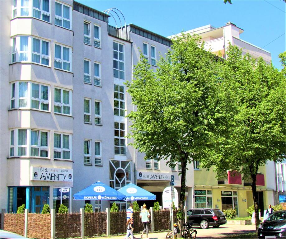 ein Gebäude in einer Stadtstraße mit Leuten, die davor laufen in der Unterkunft Hotel AMENITY in München