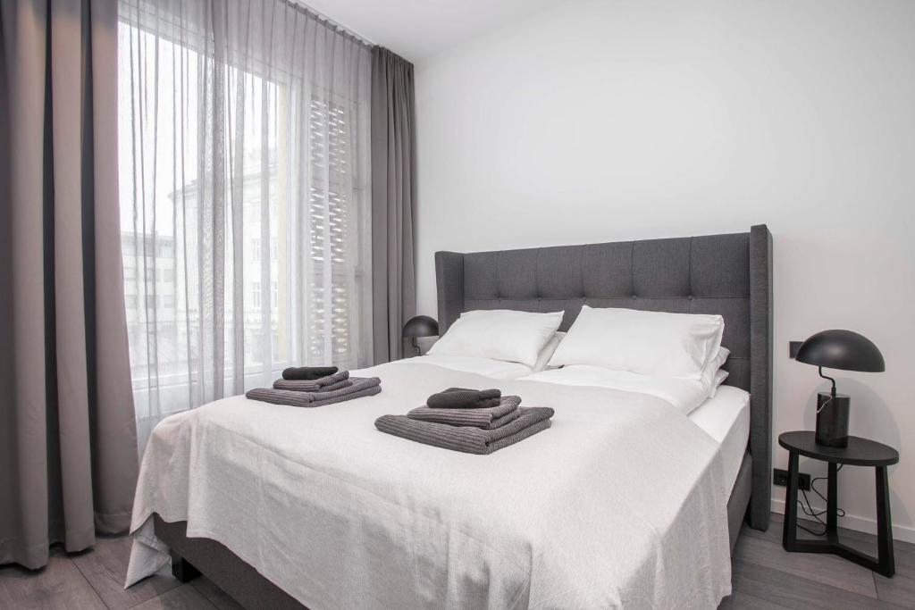 a bedroom with a white bed with towels on it at GreenKey Suite T21 in Reykjavík