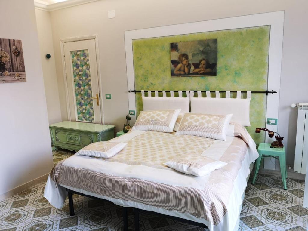 um quarto com uma cama e um quadro na parede em B&B L ORTENSIA em Bolsena