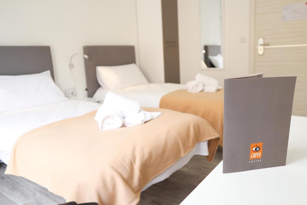2 letti in camera d'albergo con asciugamani di AM Hostel a Sliema