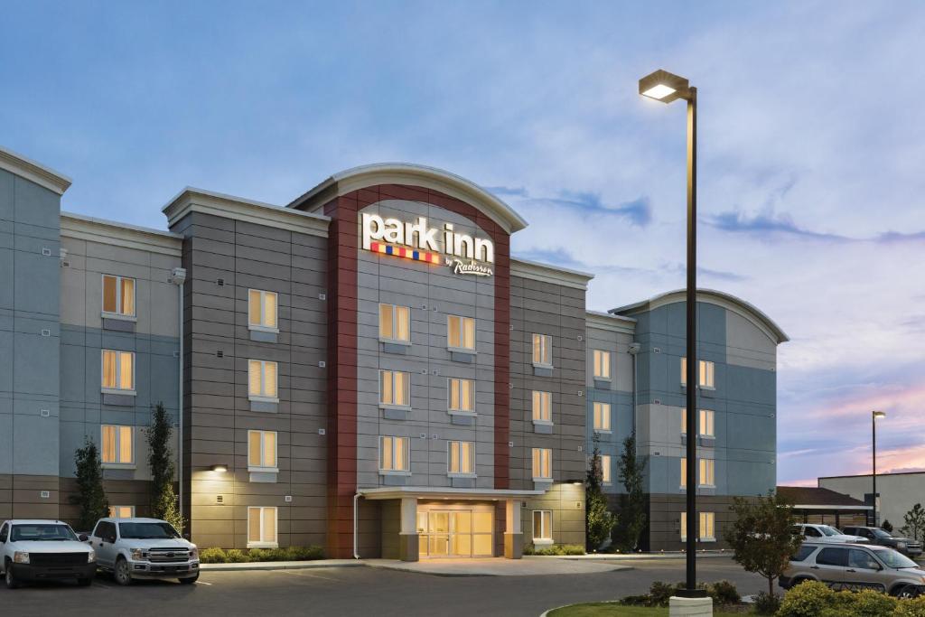 a parking lot with cars parked in front of a hotel at Park Inn by Radisson, Calgary Airport North, AB in Calgary