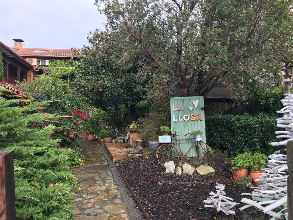 un jardín con un cartel que dice la los en Posada La Llosa de Somo en Somo