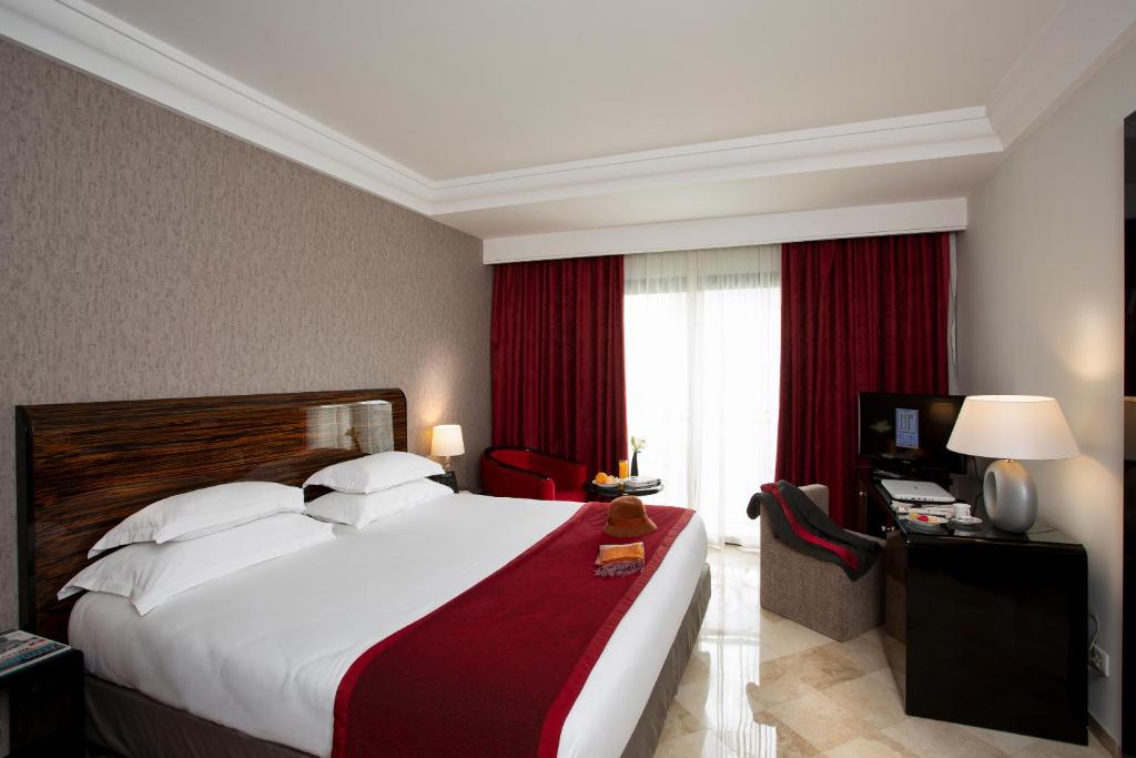 una camera d'albergo con un grande letto e una finestra di Occidental Lac Tunis a Tunisi