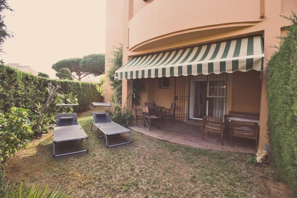 un patio con mesas, sillas y un piano en Apartamento Jardín del golf 2, en Chiclana de la Frontera