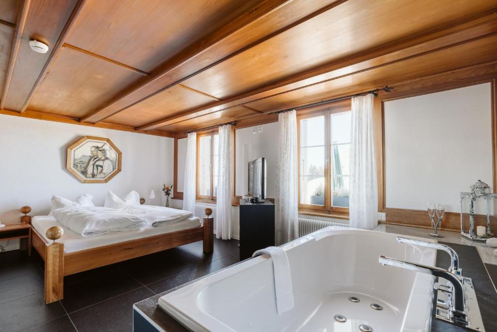 a large bathroom with a tub and a bed at Landgasthof und Seminarhotel Lueg in Kaltacker