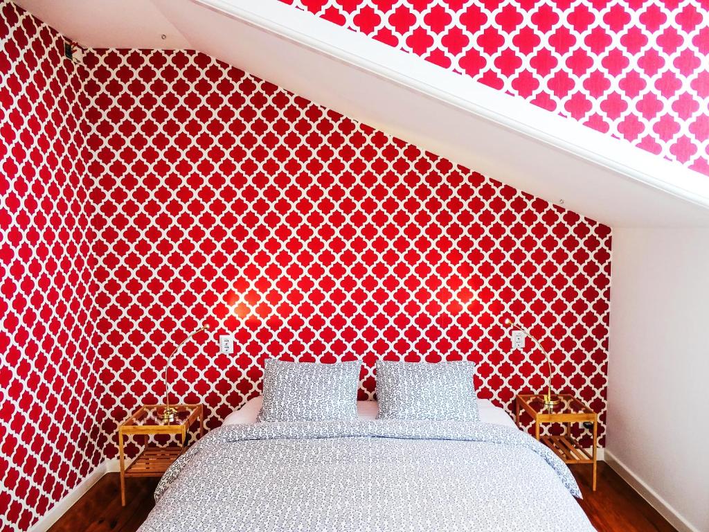 a bedroom with a red patterned wall with a bed at SUPERNOVA - Hostel & Café in Porto
