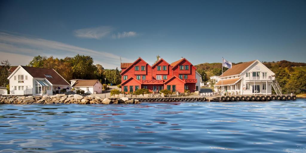 una fila di case vicino all'acqua di Sjøberg Ferie og Hotell a Østhusvik