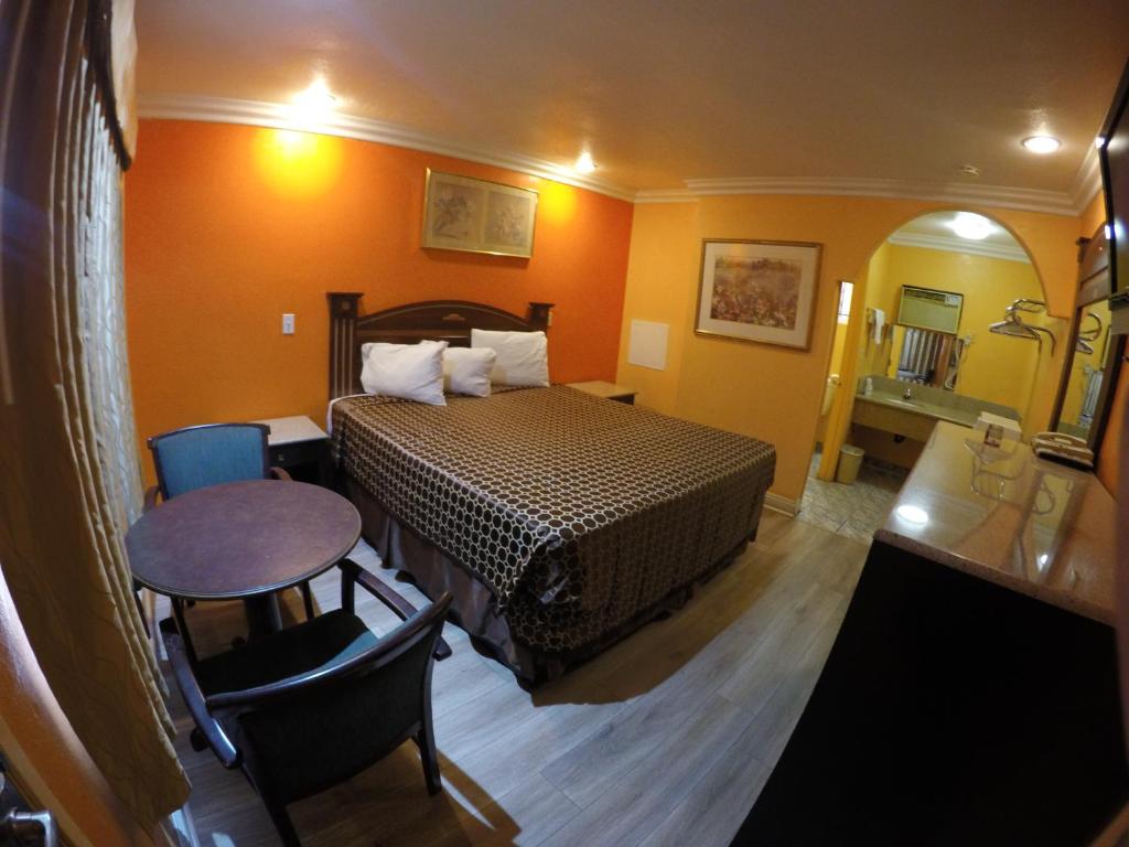 a hotel room with a bed and a table at Calico Motel in Anaheim