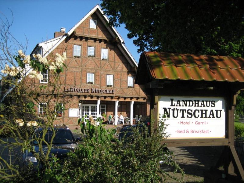 un bâtiment avec un panneau devant un bâtiment dans l'établissement Landhaus Nütschau, à Bad Oldesloe