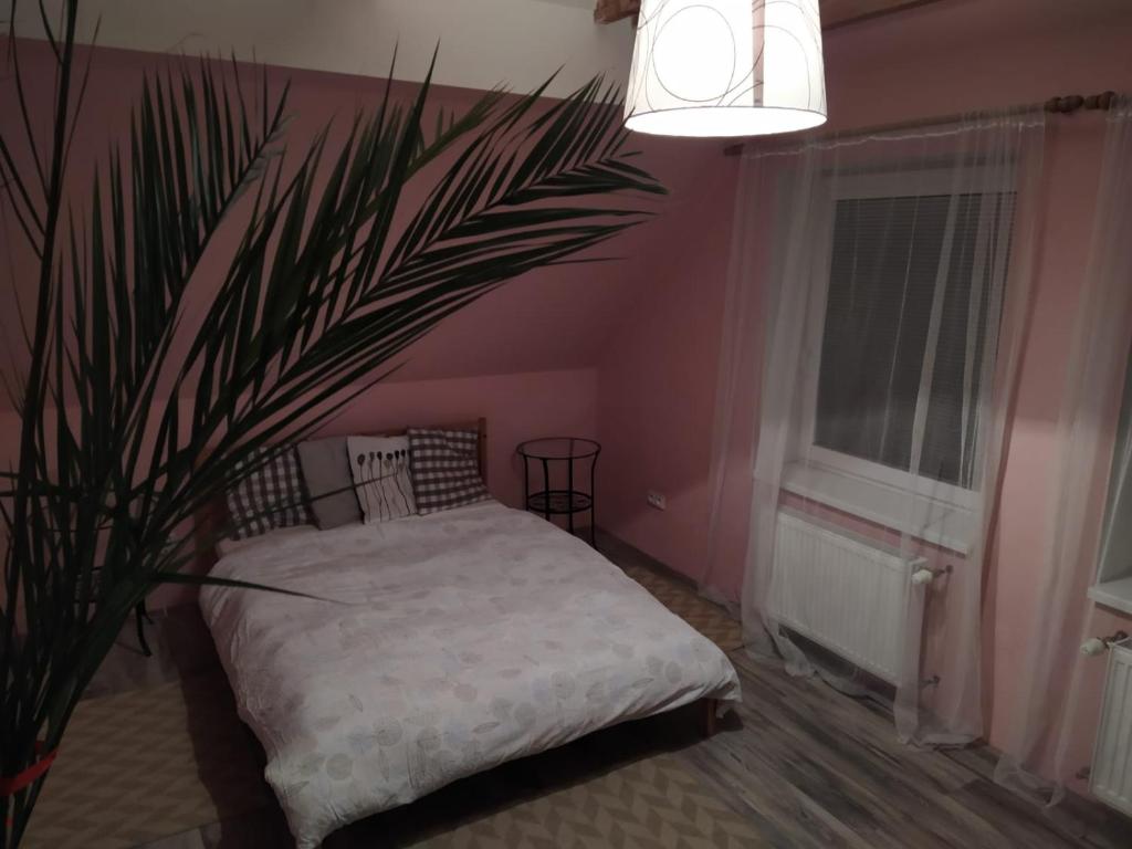 a pink bedroom with a bed and a plant at Luxury accommodation near Prague airport in Středokluky