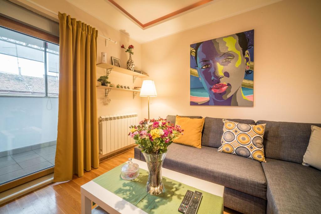 a living room with a couch and a table with flowers at Skadarlija City Break in Belgrade
