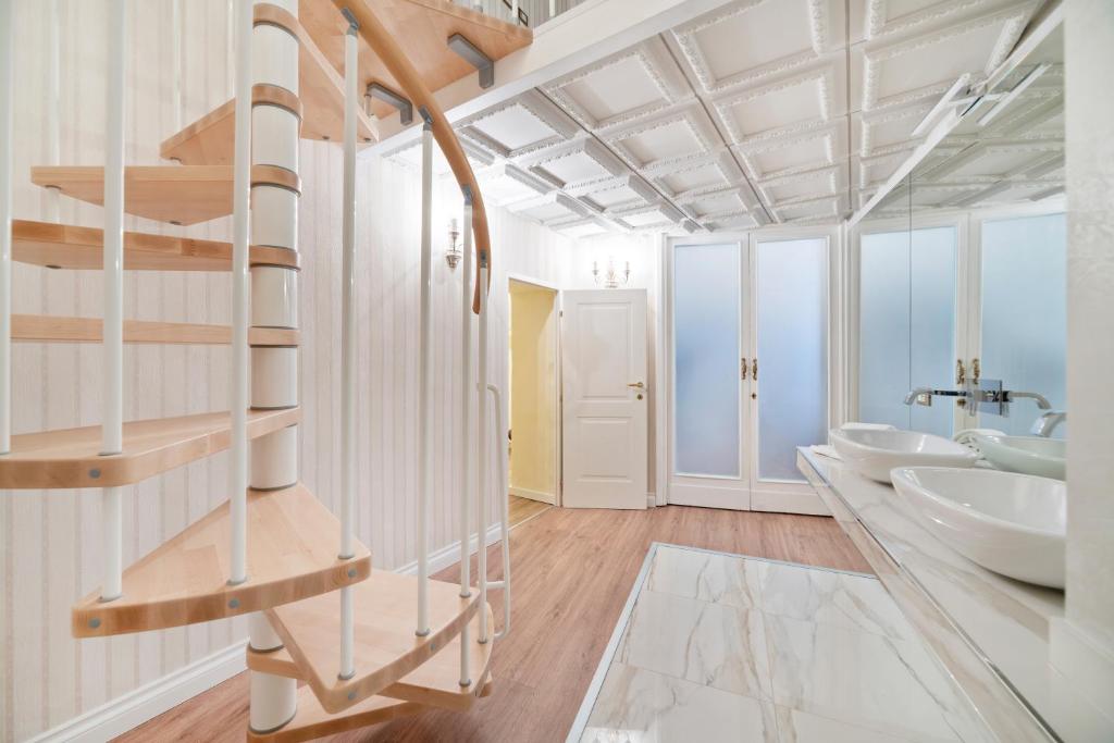 a bathroom with two sinks and a spiral staircase at Pantheon Escape in Rome