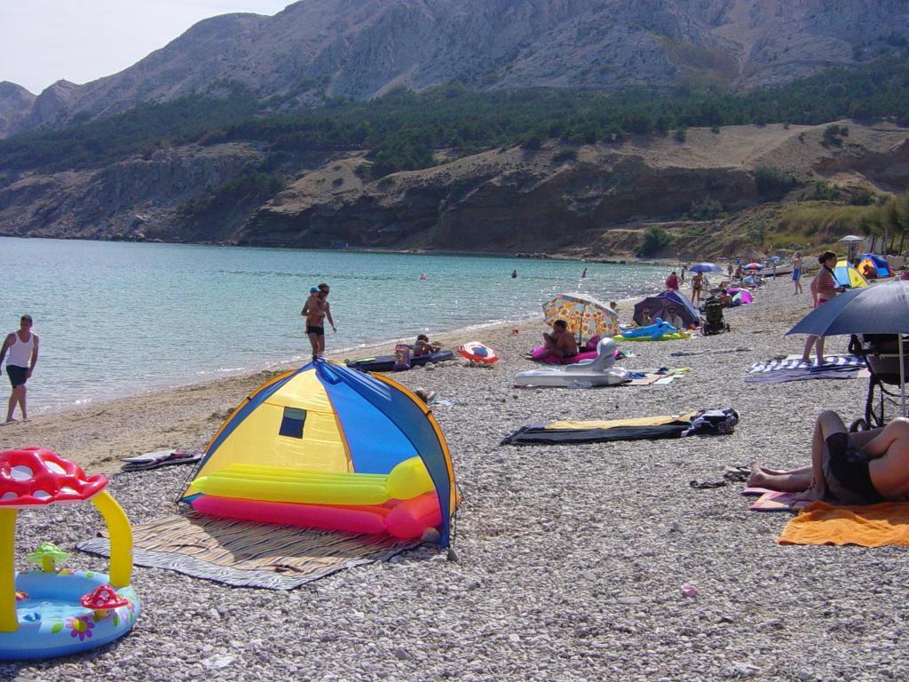 a group of people on a beach near the water at Villas Corinthia in Baška