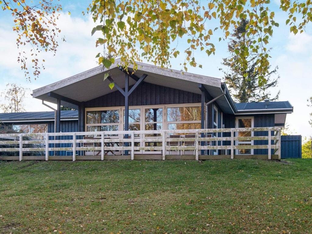 a house with a white fence in front of it at Four-Bedroom Holiday home in Knebel 6 in Skødshoved Strand