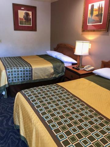 オークランドにあるCrown Lodge Motelのホテルルーム ベッド2台&ランプ付