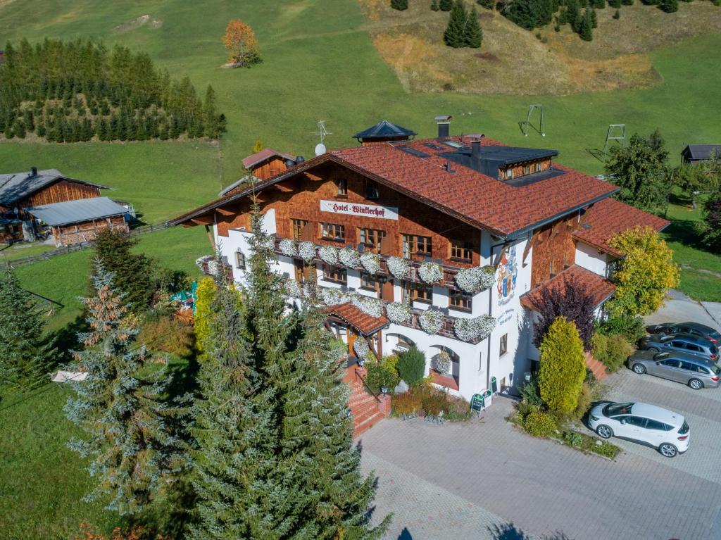 Cette chambre offre une vue sur une grande maison dotée d'un parking. dans l'établissement Hotel Winklerhof, à Holzgau