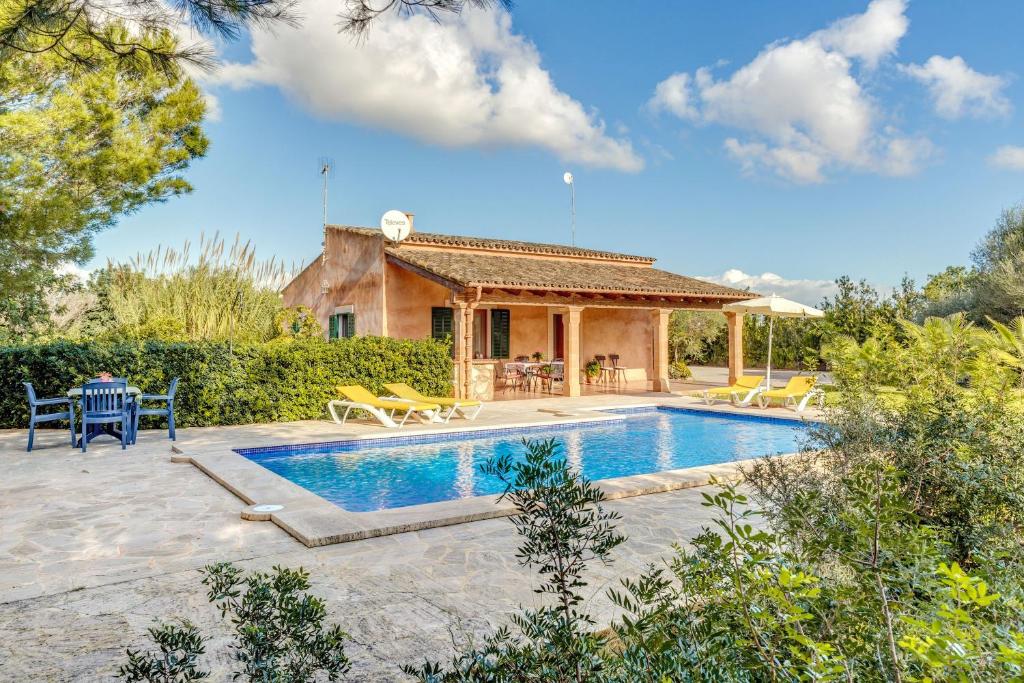 a villa with a swimming pool and a house at Casa Rústica in Portopetro