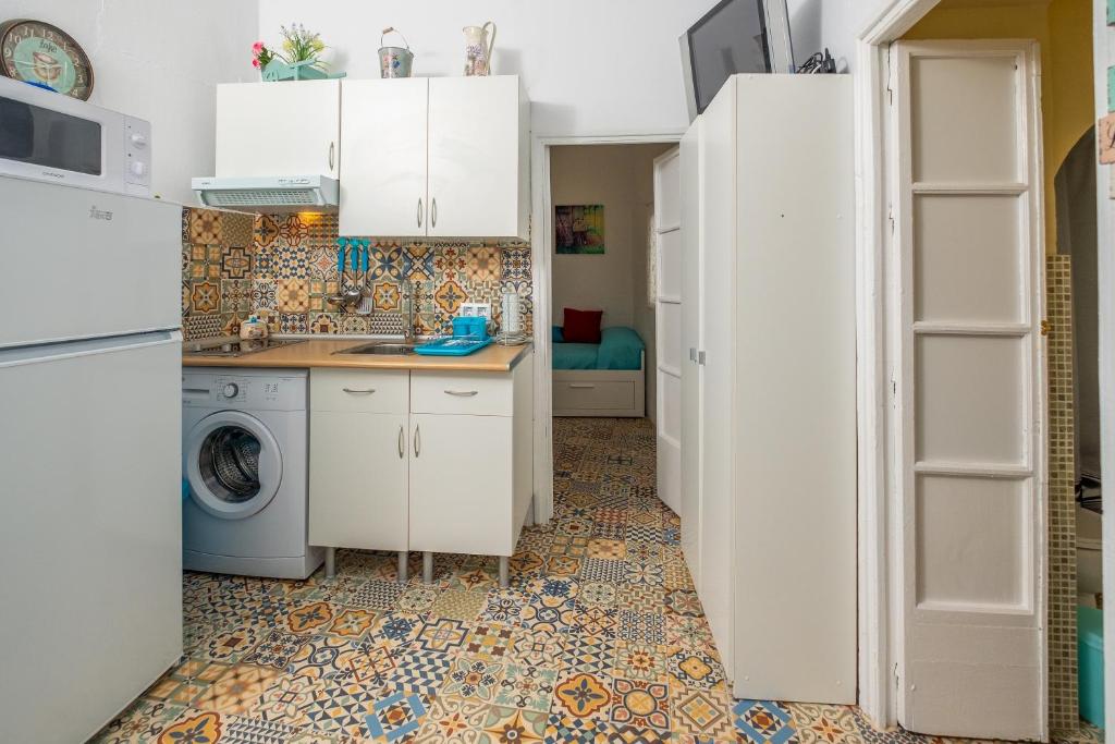 a kitchen with white cabinets and a washer and dryer at Casa Triana in Vejer de la Frontera