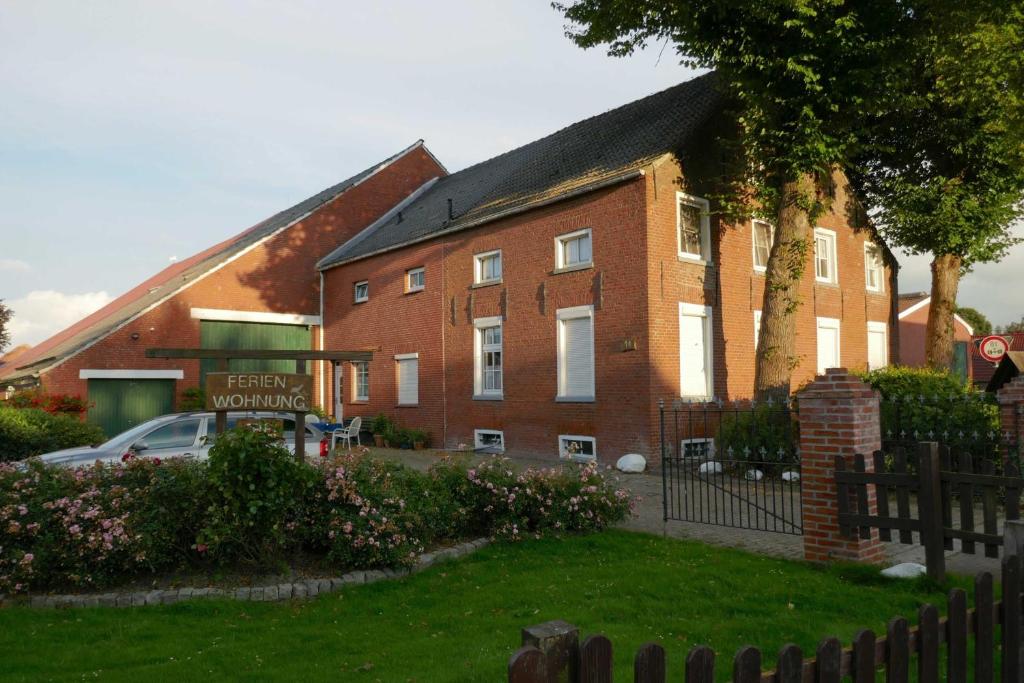 een groot bakstenen gebouw met een bord ervoor bij Ferienhof van Vlyten_ 45006 in Jemgum