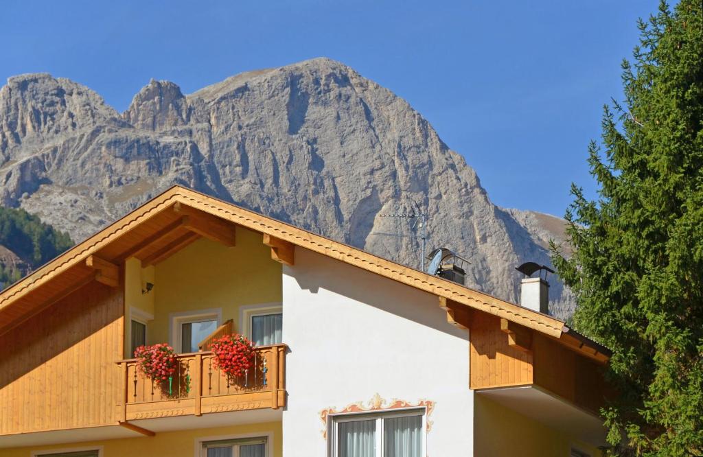 un edificio con una montaña en el fondo en Majon d'Aisciuda, en Vigo di Fassa