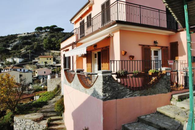 a house with balconies and stairs in a city at Appartamento Seccheto Mare in Seccheto