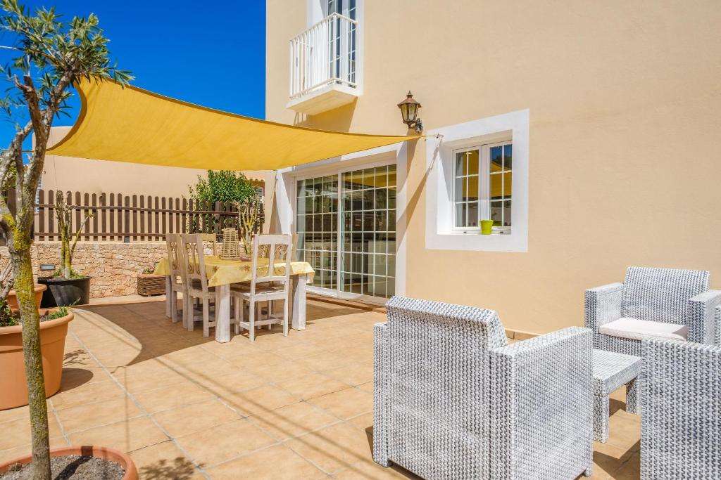 um pátio com uma mesa e cadeiras e um dossel amarelo em Casa Tomás em Sant Francesc Xavier