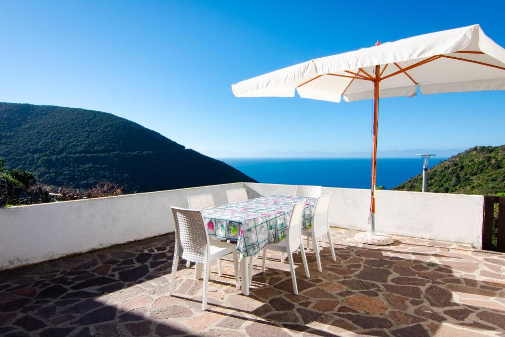 - une table et des chaises avec un parasol sur la terrasse dans l'établissement Villetta Ivana, à Marciana