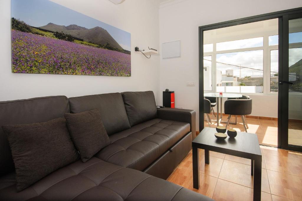 a living room with a couch and a painting on the wall at Apartamento Ye in Haría