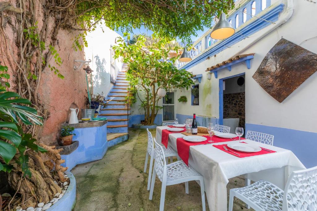 una mesa y sillas en el patio de una casa en Villa Ithaka Petit, en Artà