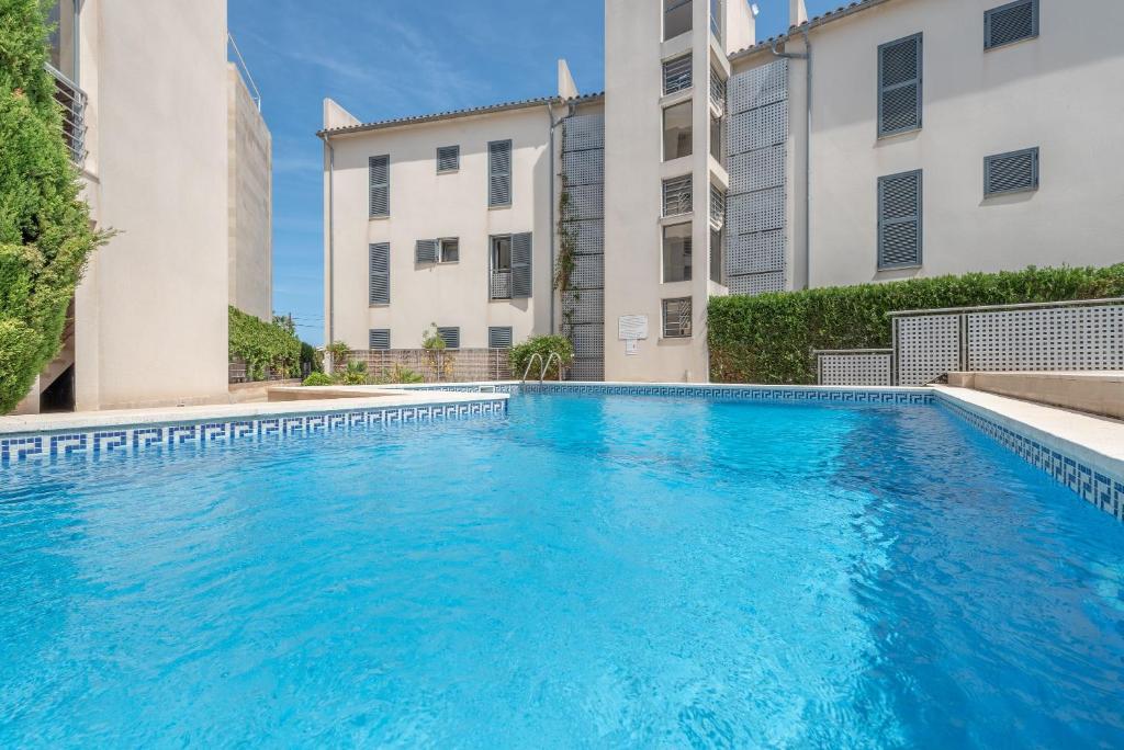 a swimming pool in front of two buildings at Residencial Llenaire in El Port