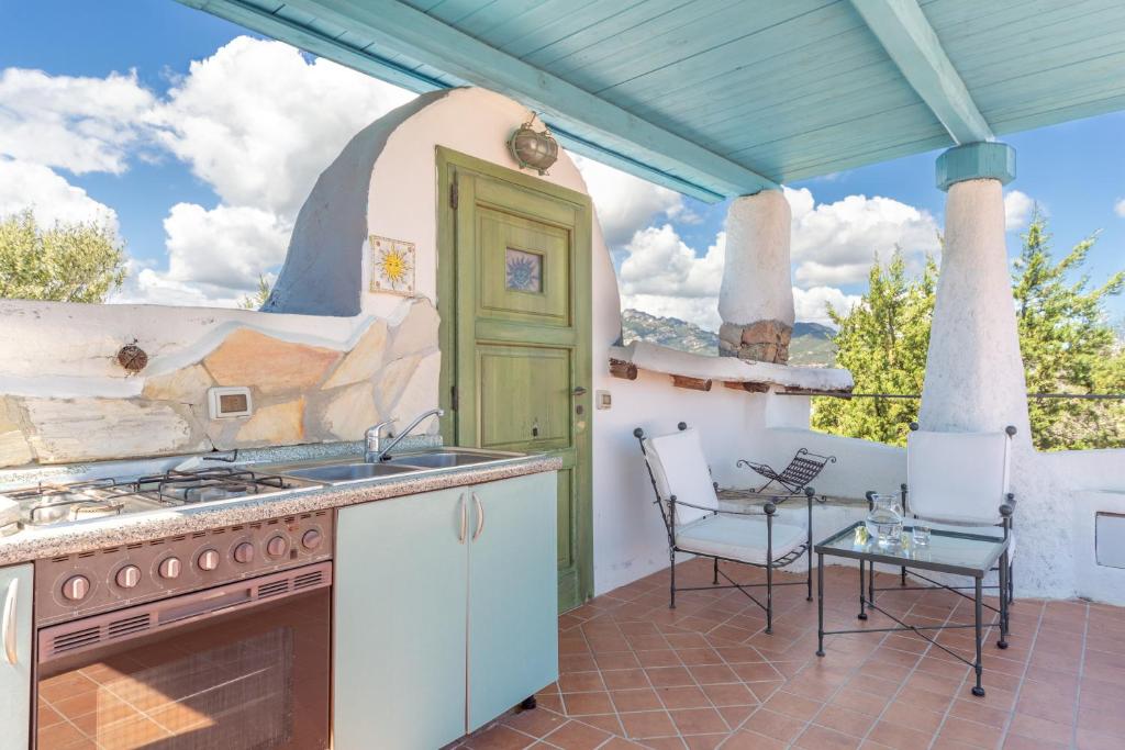 een keuken met een fornuis en stoelen op een patio bij Casa Penthouse in Porto Rotondo