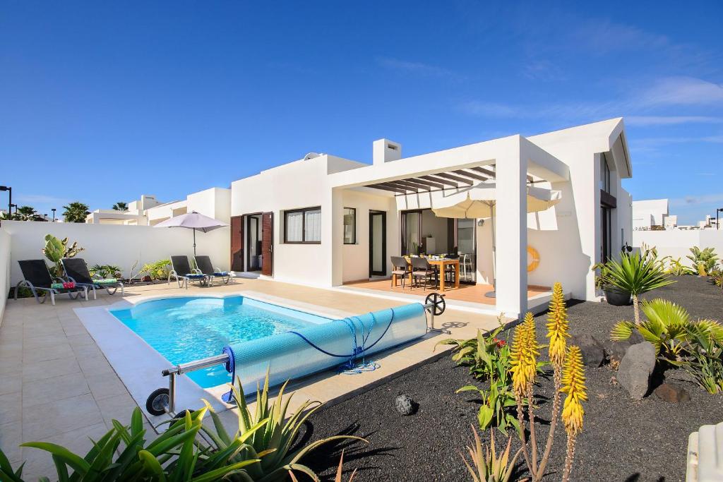 een villa met een zwembad voor een huis bij Villa Luna in Playa Blanca