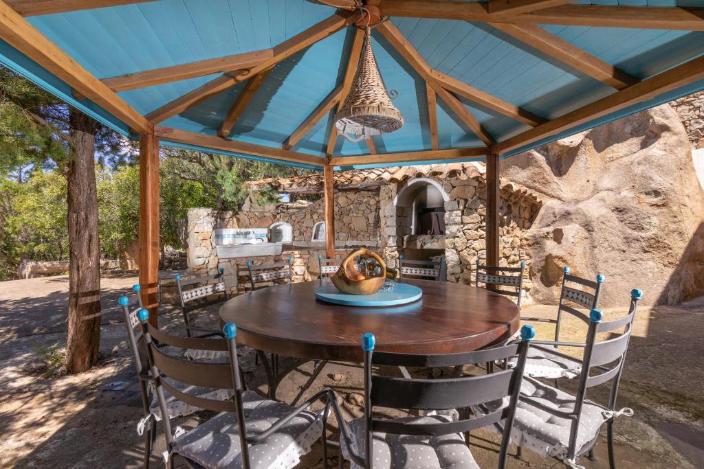 a wooden table and chairs under a pavilion at Villa Nuraghe in Porto Rotondo