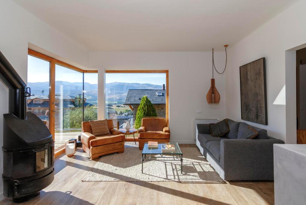 een woonkamer met een bank en een open haard bij Fantástica casa de diseño en Alp in Alp