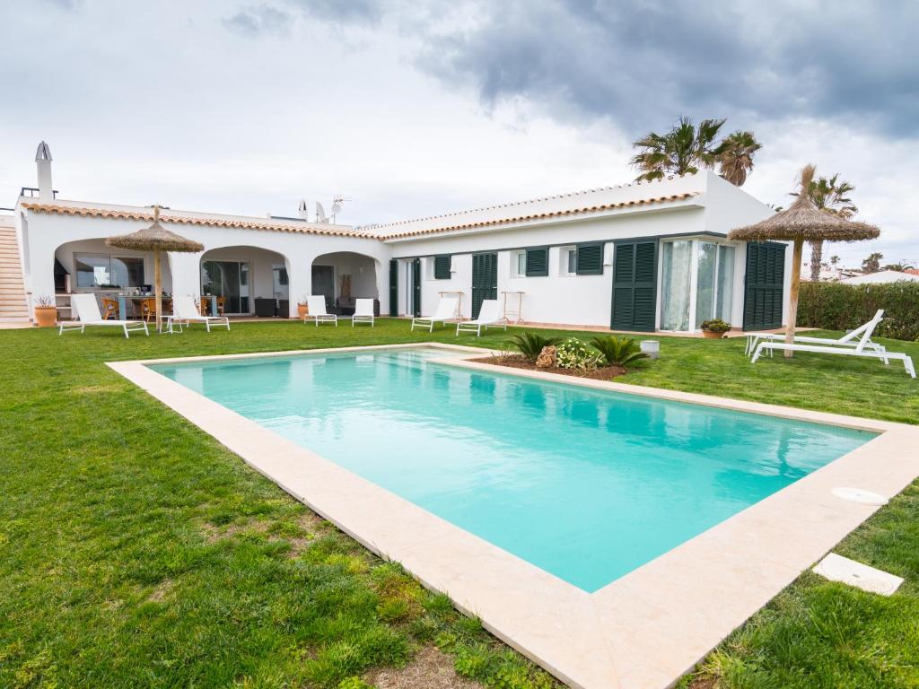 a villa with a swimming pool in front of a house at Villa De Lujo Frente A La Playa in Binisafua