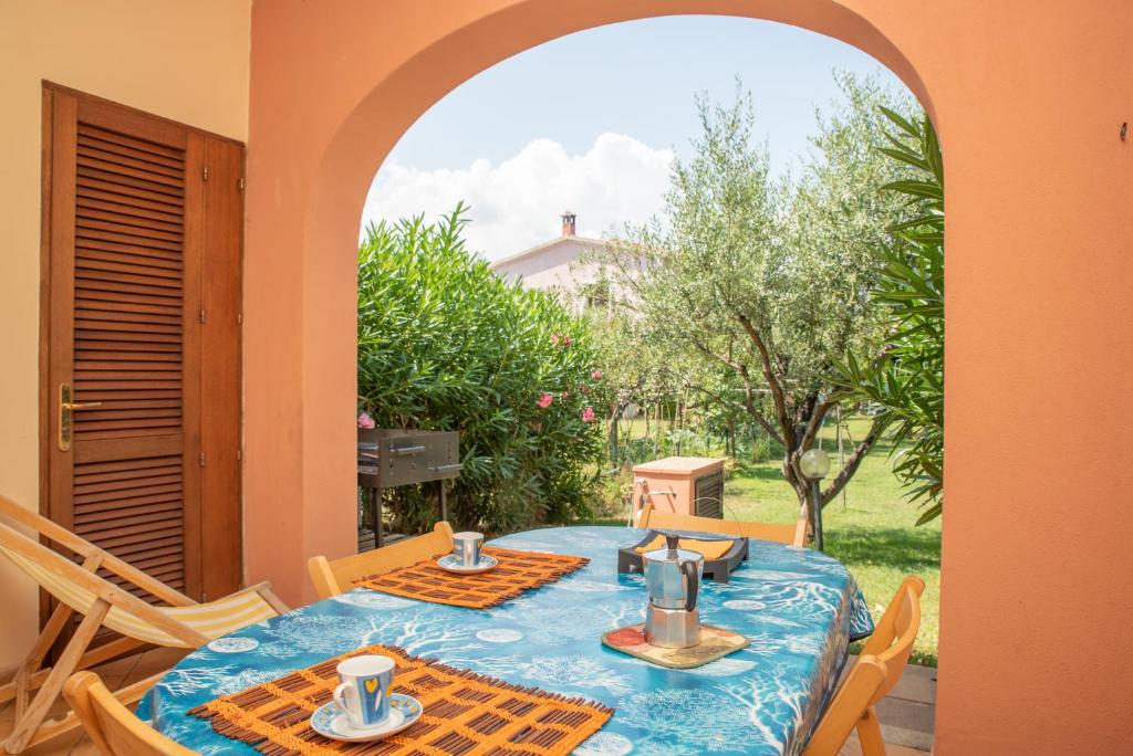 un tavolo con una tovaglia blu su un patio di Villetta Olivastro a San Teodoro
