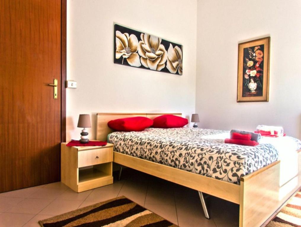 a bedroom with a bed with red pillows on it at The History Apartment in Montagnana