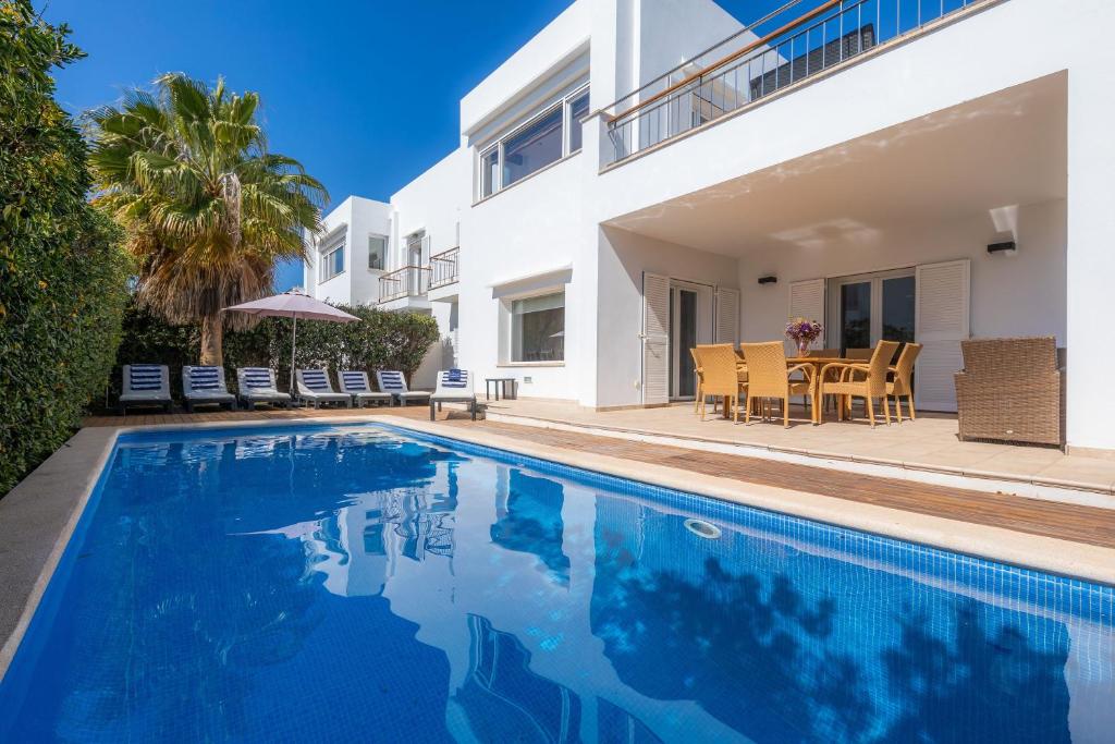 uma villa com piscina em frente a uma casa em Villa Costa Eugenia em Cala d´Or