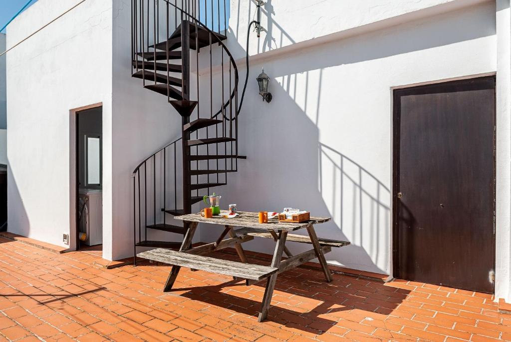 patio con tavolo e scala a chiocciola di Apartamento Rocio - solo familias a Conil de la Frontera