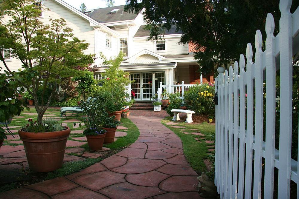 a white fence in front of a house with potted plants at Inn at Occidental in Occidental