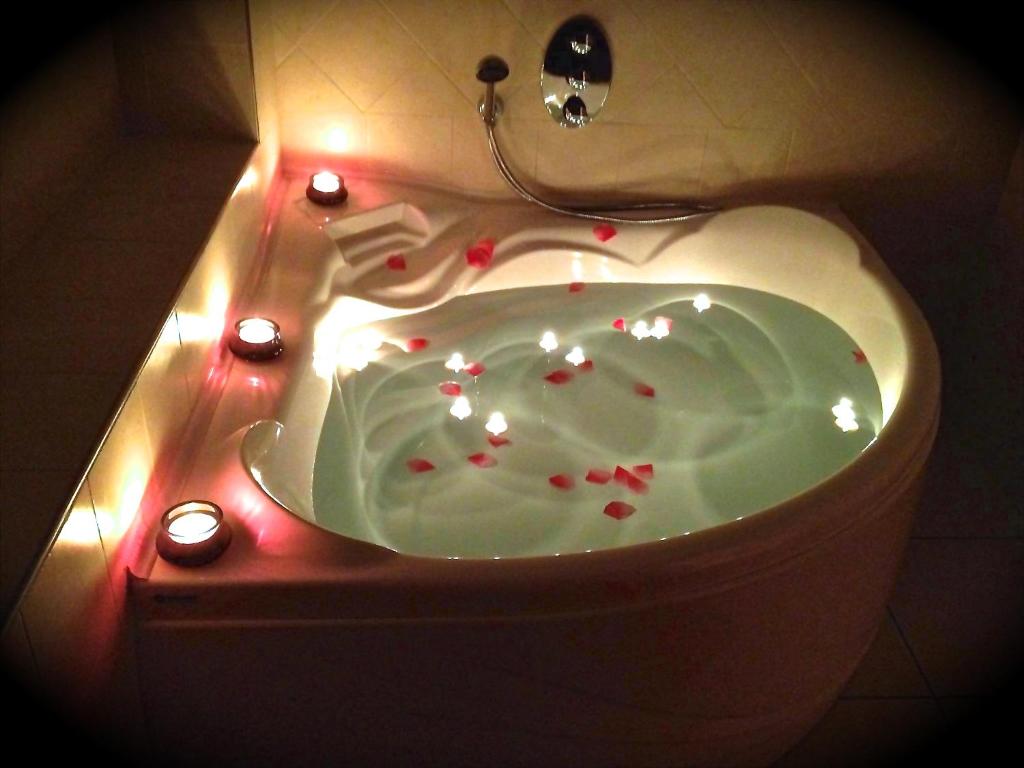 a white sink with red sprinkles in a bathroom at Le Suite Bracciano in Bracciano